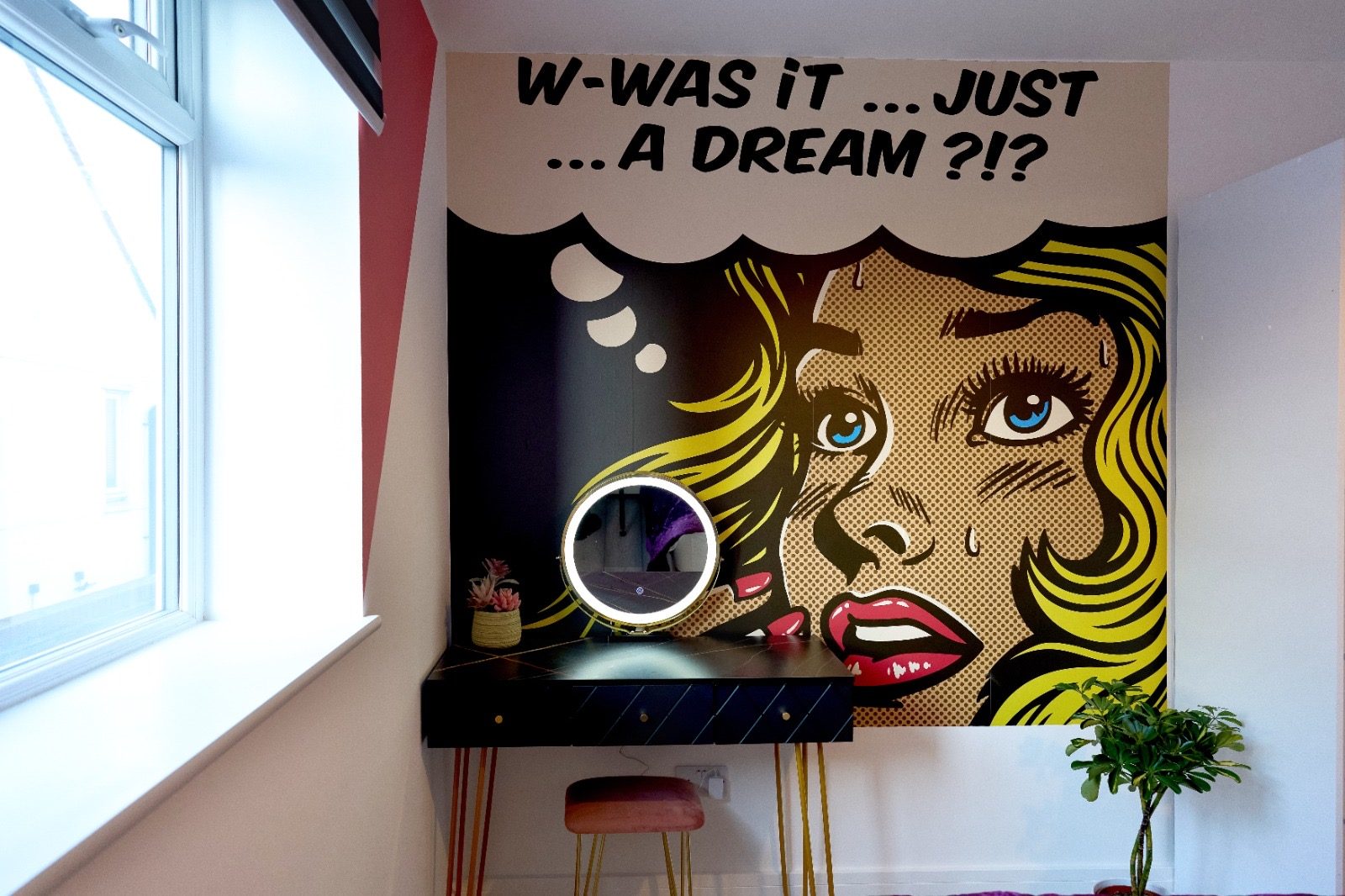 Lit vanity mirror against a comic-strip mural