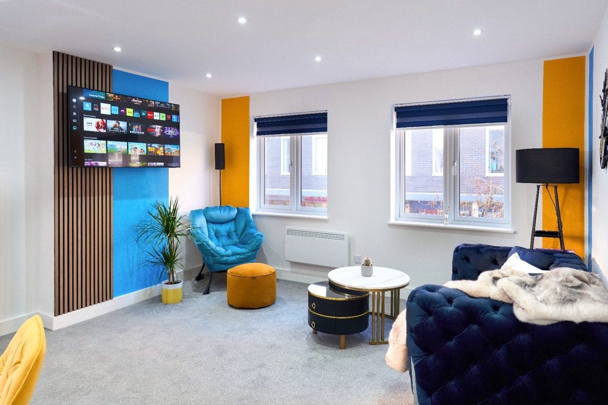 Living room with a wall-mounted smart TV and blue panelling