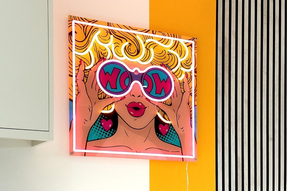 Neon pop-art sign mounted on a panelled kitchen wall